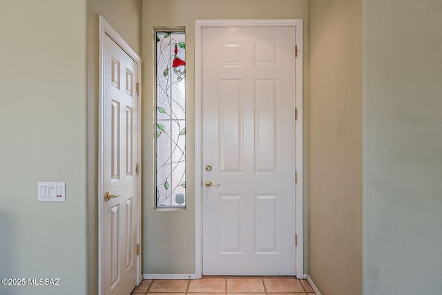 foyer entrance featuring light tile patterned floors and baseboards