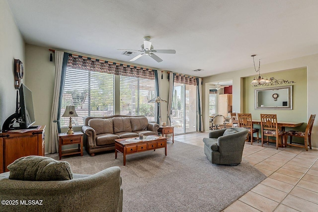 living room with ceiling fan, visible vents, and light tile patterned floors