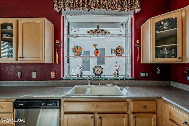 kitchen featuring light brown cabinets, glass insert cabinets, a sink, and stainless steel dishwasher