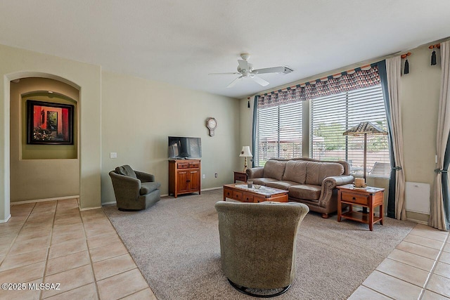 living room with light tile patterned flooring, baseboards, light carpet, and ceiling fan