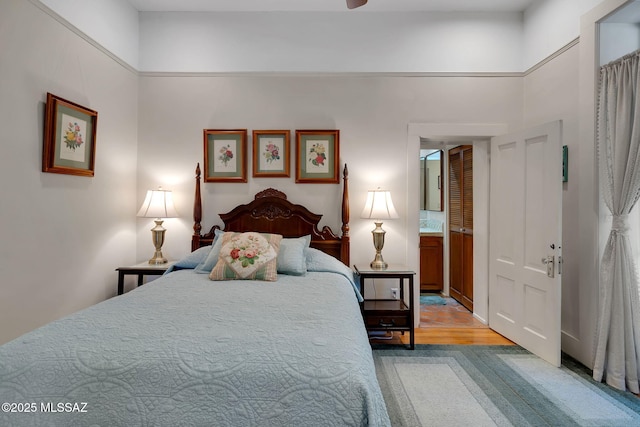 bedroom with ensuite bathroom and light wood-type flooring