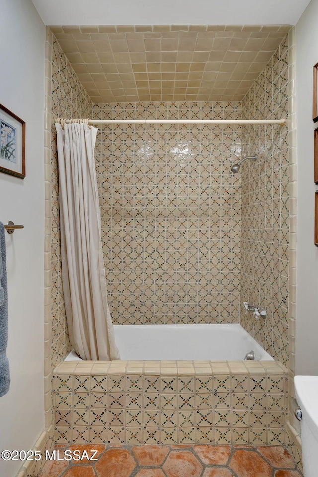 bathroom with toilet, tile patterned floors, and tiled shower / bath combo
