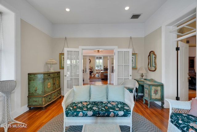 living room featuring recessed lighting, visible vents, french doors, and wood finished floors