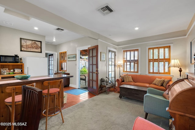 tiled living area with carpet, visible vents, and french doors