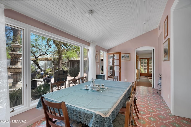dining area featuring arched walkways, wooden ceiling, and lofted ceiling