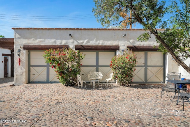 exterior space with stucco siding and an outdoor structure