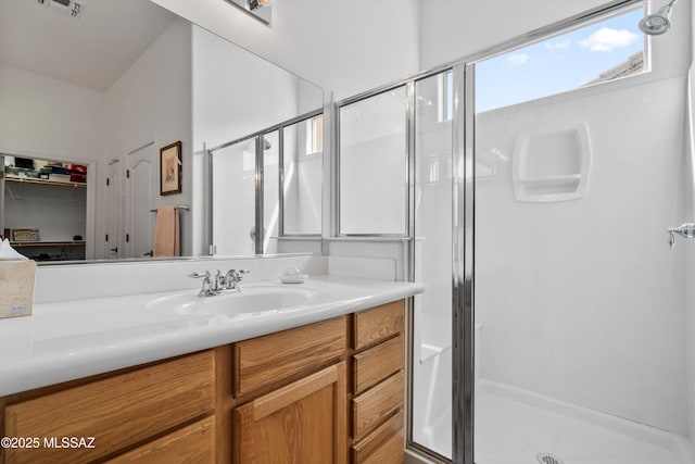 bathroom with vanity, visible vents, and a shower stall