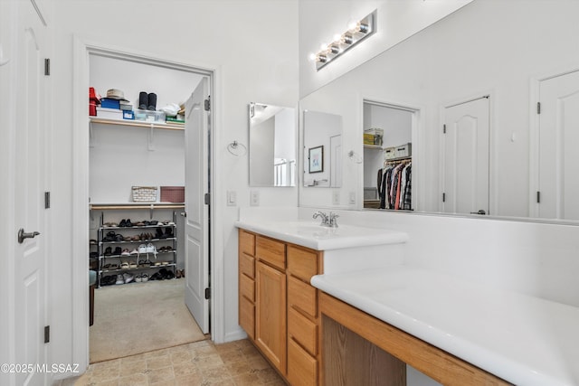 bathroom featuring vanity and a walk in closet