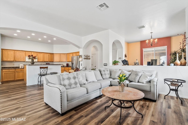 living room with visible vents, dark wood-style flooring, recessed lighting, and an inviting chandelier