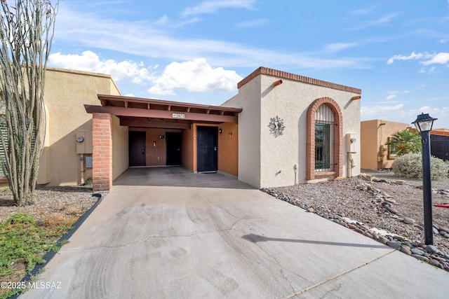 view of front of home featuring stucco siding, driveway, and an attached carport