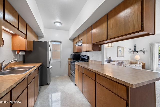 kitchen featuring under cabinet range hood, a sink, electric range oven, dishwasher, and a peninsula