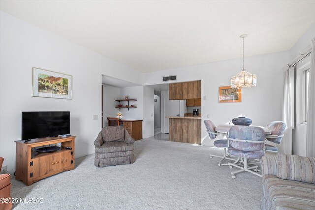 living room with light colored carpet, visible vents, and a chandelier