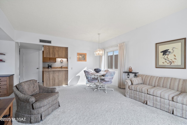 living room with light colored carpet, a chandelier, and visible vents