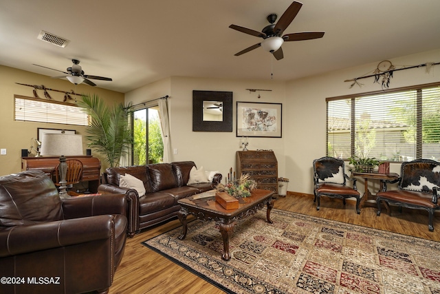 living room featuring wood finished floors, visible vents, and ceiling fan