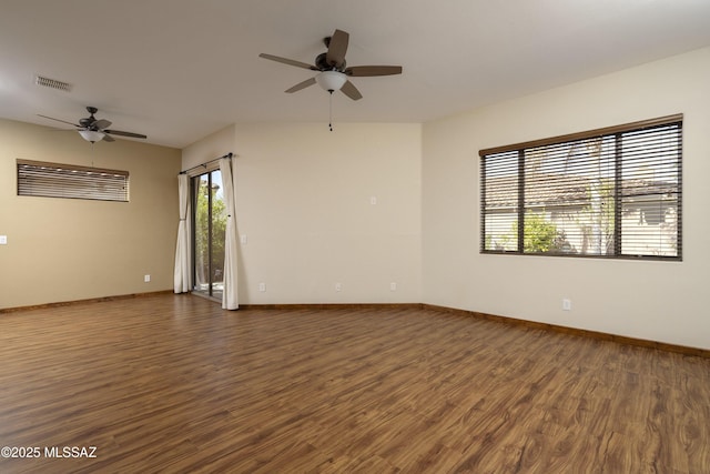 empty room with dark wood finished floors, visible vents, and ceiling fan