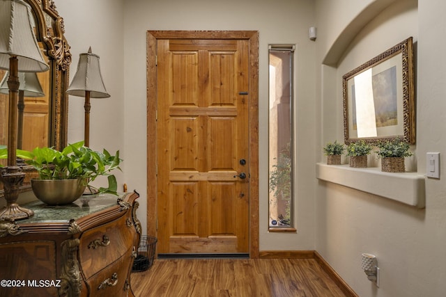 foyer featuring baseboards and wood finished floors