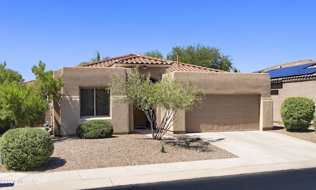 view of front of home featuring a tile roof, driveway, stucco siding, and an attached garage