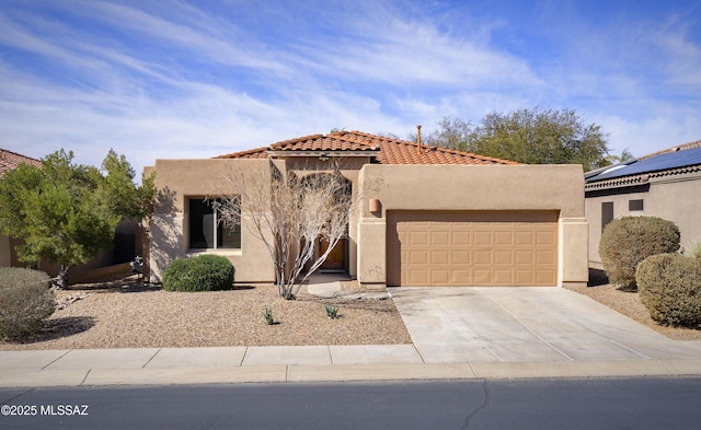 view of front of property with a tile roof, stucco siding, concrete driveway, and a garage