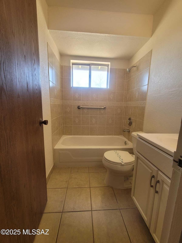 full bathroom with a textured ceiling, vanity, tile patterned flooring, toilet, and washtub / shower combination