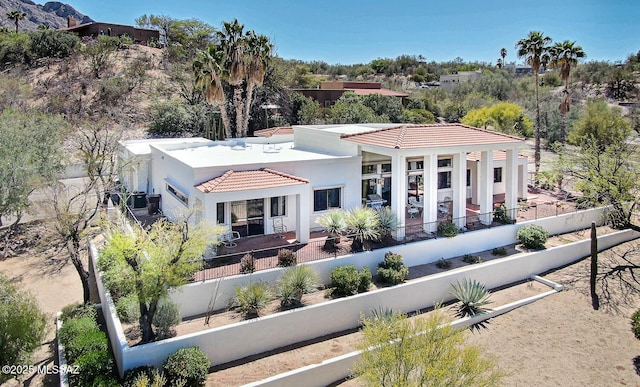 exterior space featuring a fenced backyard, a tile roof, a patio, and stucco siding