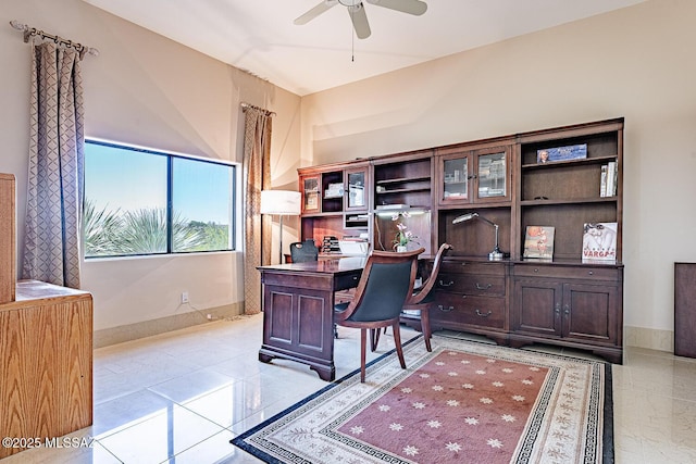 office space featuring ceiling fan and baseboards