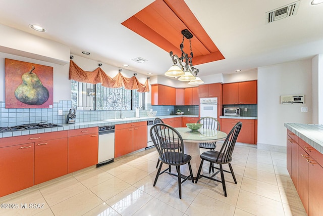 kitchen with gas stovetop, visible vents, a toaster, and white double oven