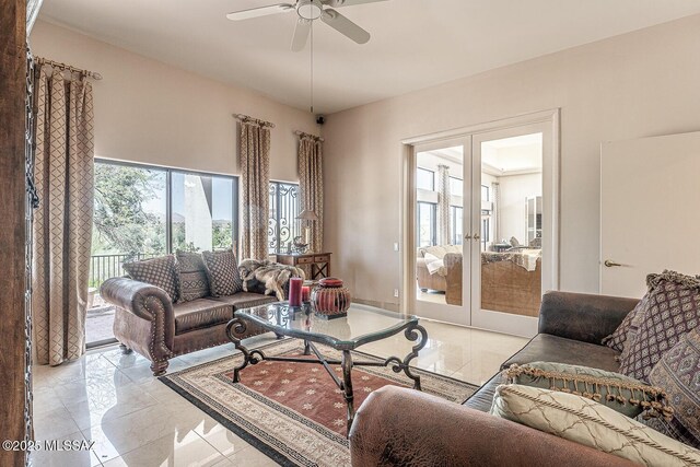 living area featuring french doors, ceiling fan, and baseboards