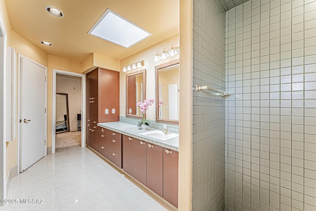 full bath with a walk in shower, double vanity, marble finish floor, and a sink