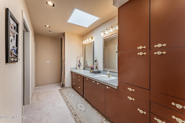 full bath with recessed lighting, vanity, visible vents, and a skylight