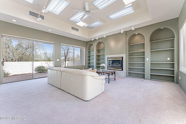 unfurnished living room with carpet flooring, visible vents, and built in features