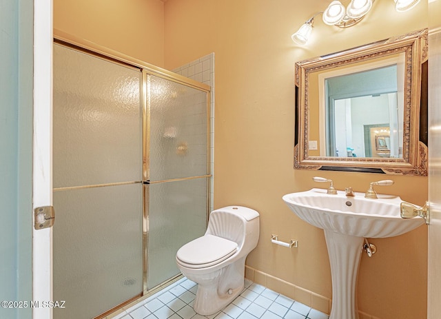 full bathroom featuring a shower stall, tile patterned floors, baseboards, and toilet
