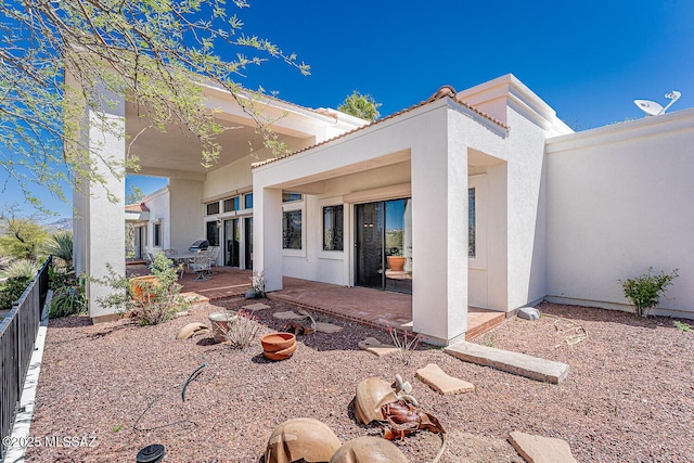back of house featuring a patio, stucco siding, and fence