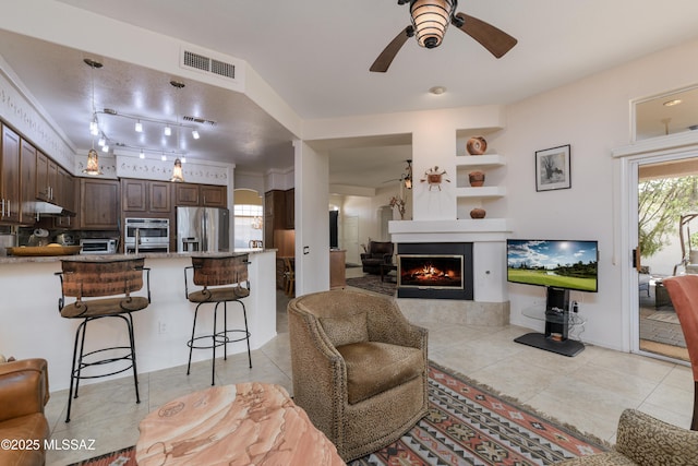 living room featuring visible vents, ceiling fan, and light tile patterned floors