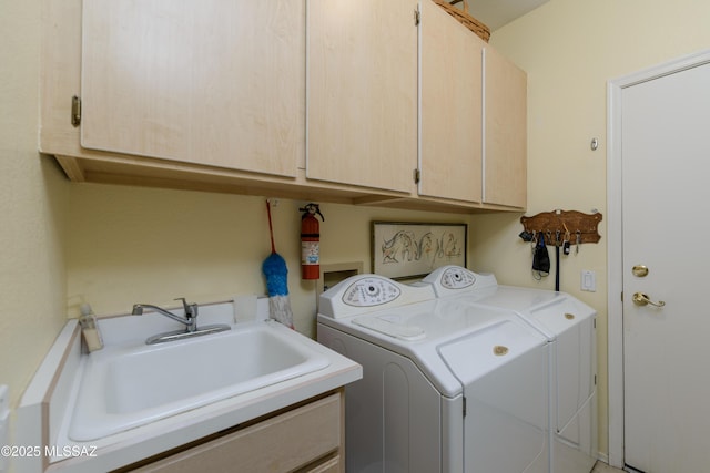 laundry room with a sink, cabinet space, and independent washer and dryer