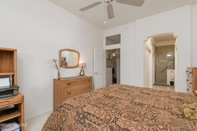 bedroom with carpet floors, arched walkways, a ceiling fan, and ensuite bathroom