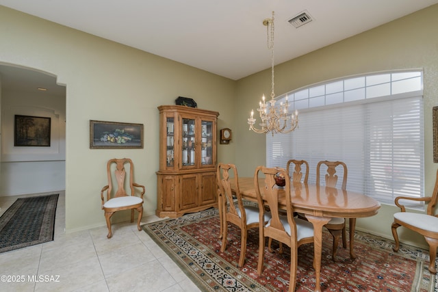 dining room with visible vents, arched walkways, light tile patterned floors, baseboards, and an inviting chandelier