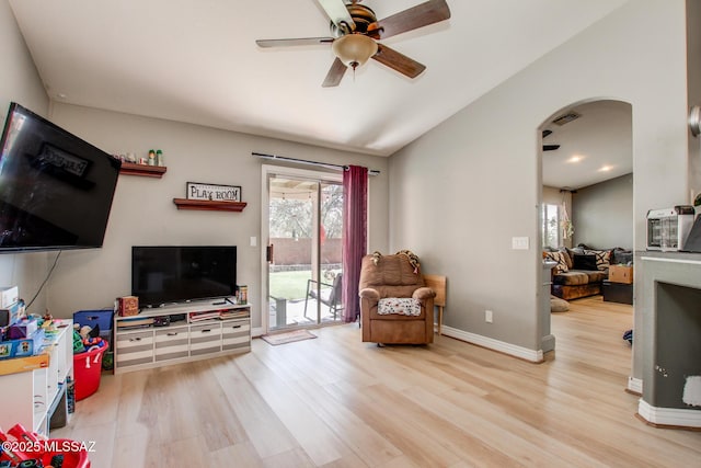 living area featuring vaulted ceiling, arched walkways, visible vents, ceiling fan, and wood finished floors