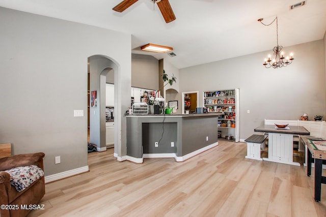 kitchen featuring arched walkways, visible vents, light wood-style floors, and ceiling fan with notable chandelier