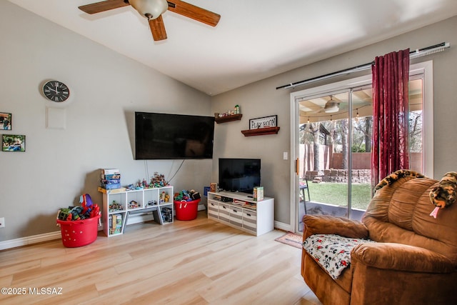 living room featuring baseboards, ceiling fan, vaulted ceiling, and light wood-type flooring