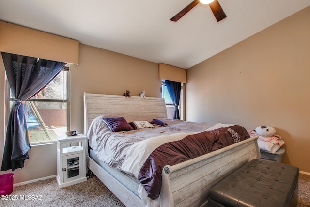 bedroom with a ceiling fan, carpet, multiple windows, and vaulted ceiling