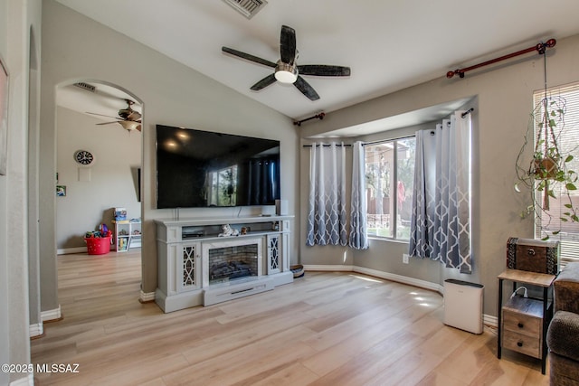 living room with wood finished floors, vaulted ceiling, and a ceiling fan