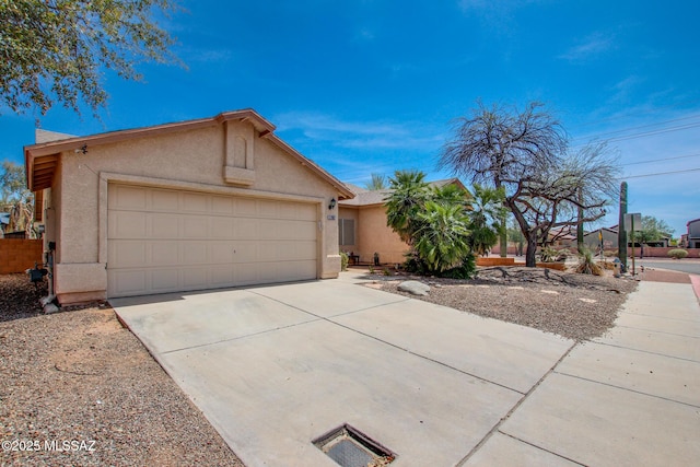 view of front of house featuring driveway, stucco siding, and a garage