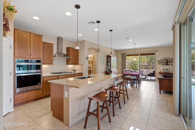 14082 N Tiyo Point Trl, Marana, AZ 85658 - kitchen with tasteful backsplash, visible vents, wall chimney exhaust hood, appliances with stainless steel finishes, and a sink