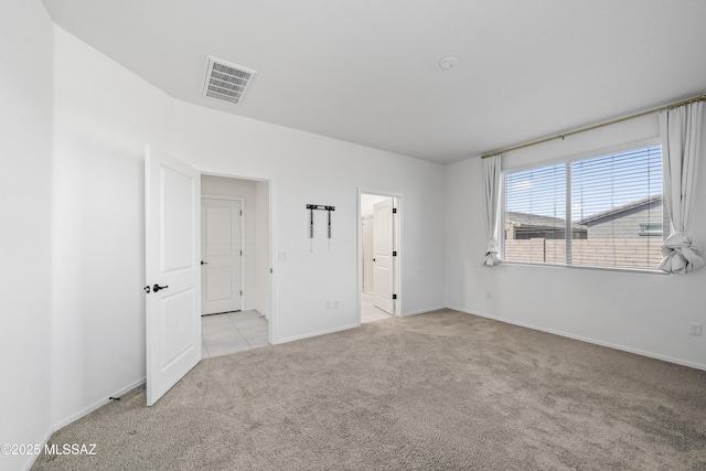 empty room featuring light colored carpet, baseboards, and visible vents