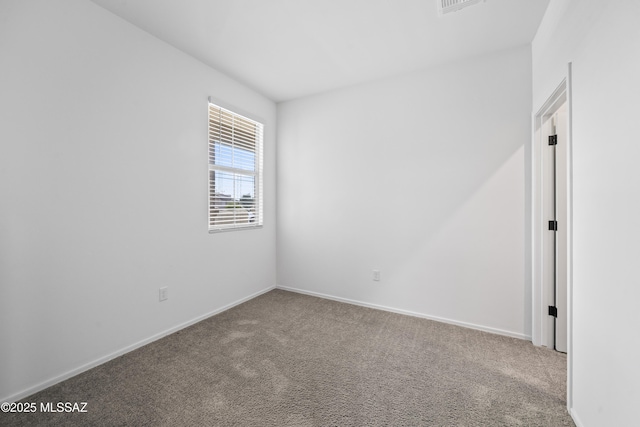 carpeted spare room with baseboards
