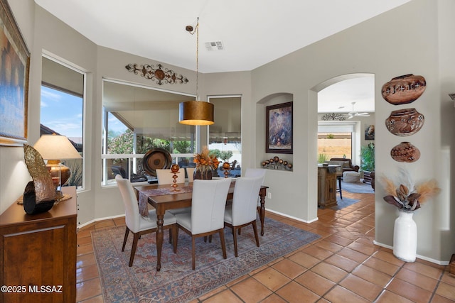 tiled dining area with ceiling fan, baseboards, and visible vents