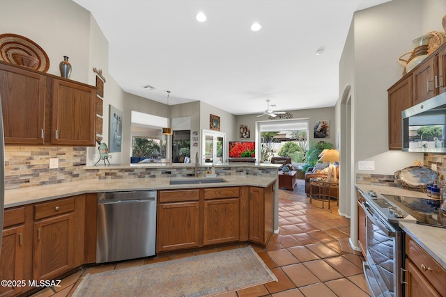 kitchen with a sink, open floor plan, tasteful backsplash, and stainless steel appliances
