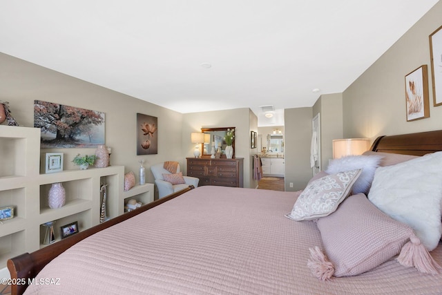 bedroom with ensuite bathroom and visible vents