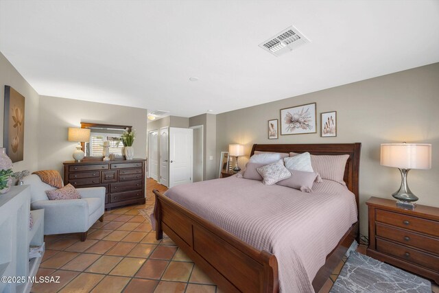 bedroom with visible vents, a closet, and light tile patterned flooring