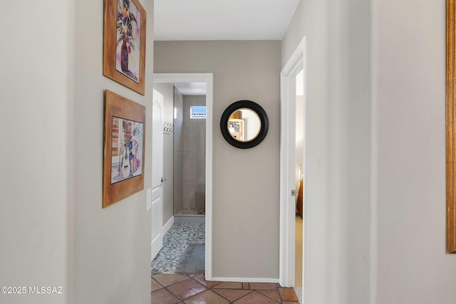 hallway with tile patterned floors and baseboards
